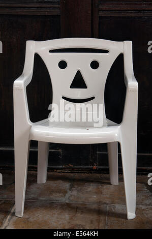 Child`s plastic chair with face Stock Photo